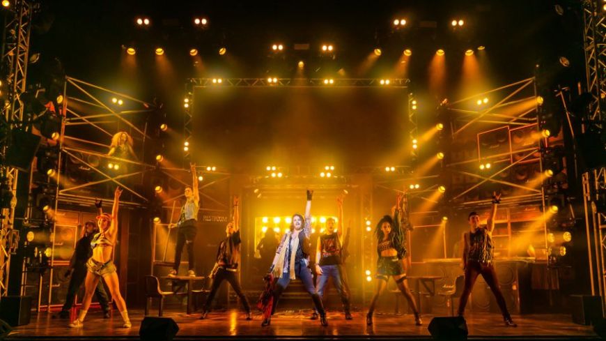 Rock of Ages production shot of ensemble with air punch choreography