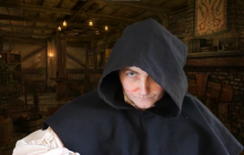 Actor Lexi Wolfe as Henry V with a scar on her face and a hood