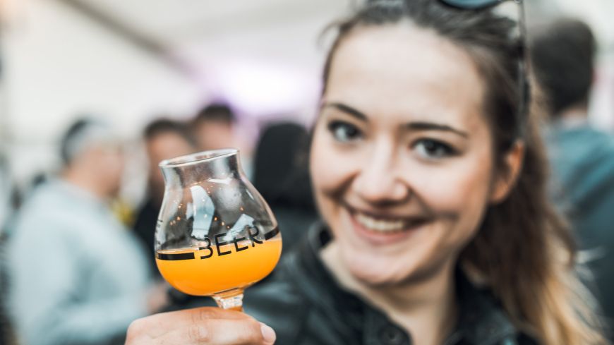 Girl holds up little glass of beer at Edinburgh Craft Beer Festival 
