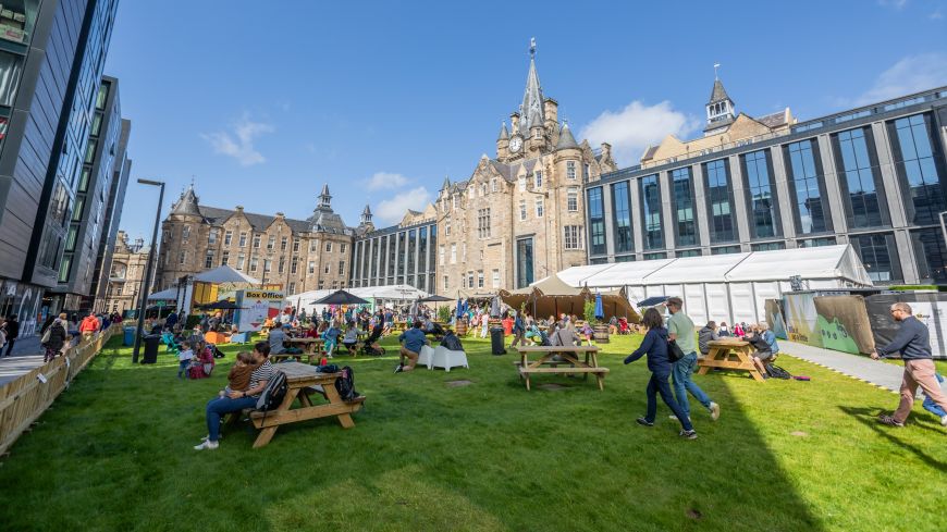 People enjoy the grassy courtyard at the Edinburgh Futures Institute during the Book Festival