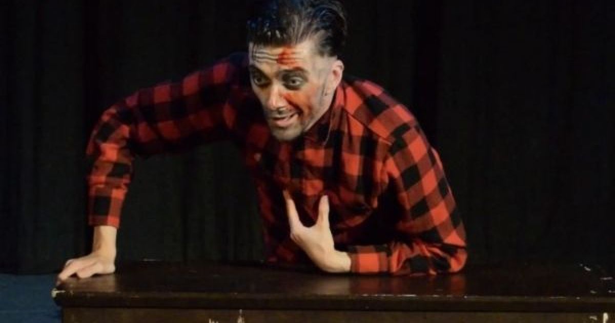 Simon Shaw as Ed Gein gestures with blood on his face