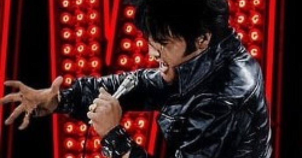 Image of Elvis in black leather outfit with Elvis sign in red lights behind