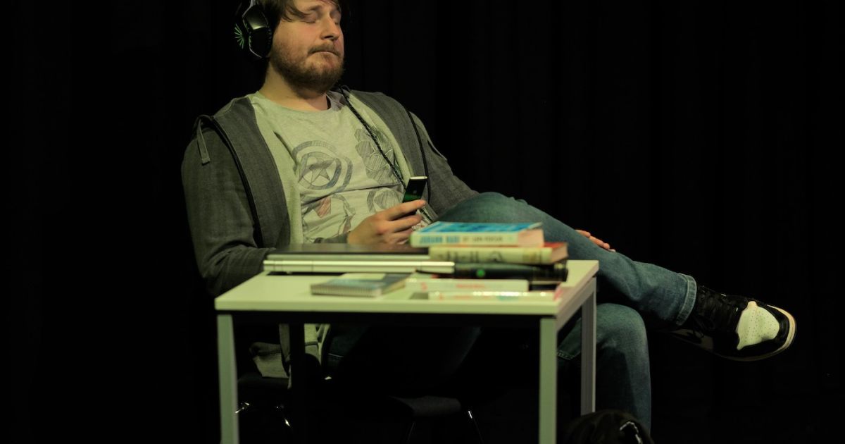 Jnusz sits in chaos at his desk, wondering how to remove the clutter and focus on his studies.
