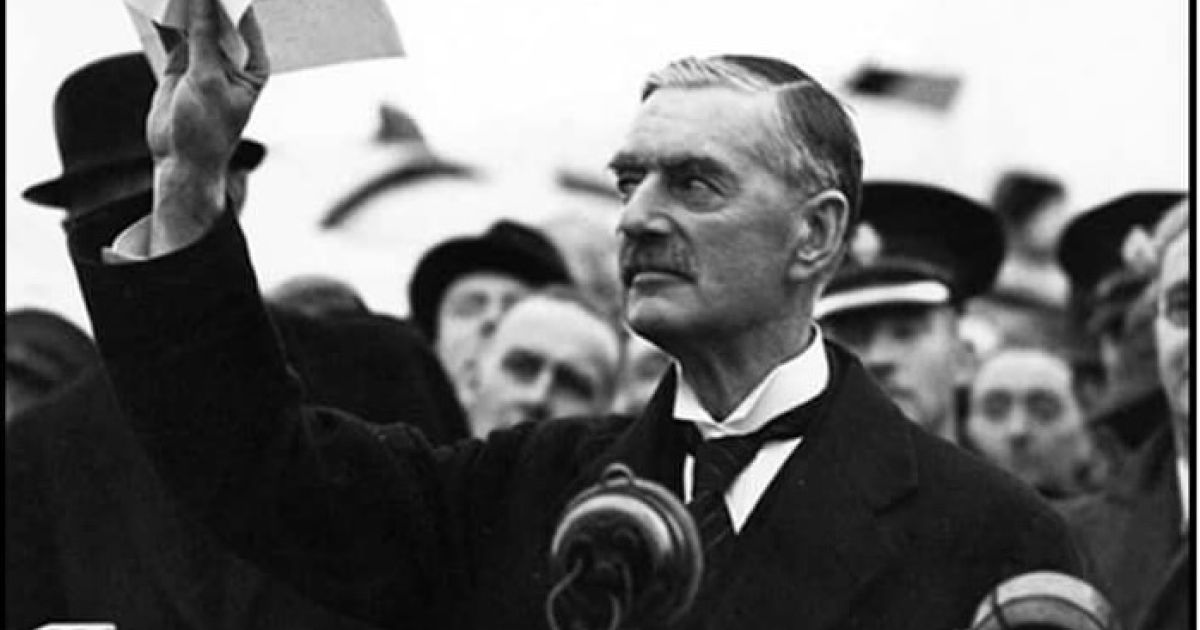 Image of Chamberlain with arm in the air - black and white image from WWII