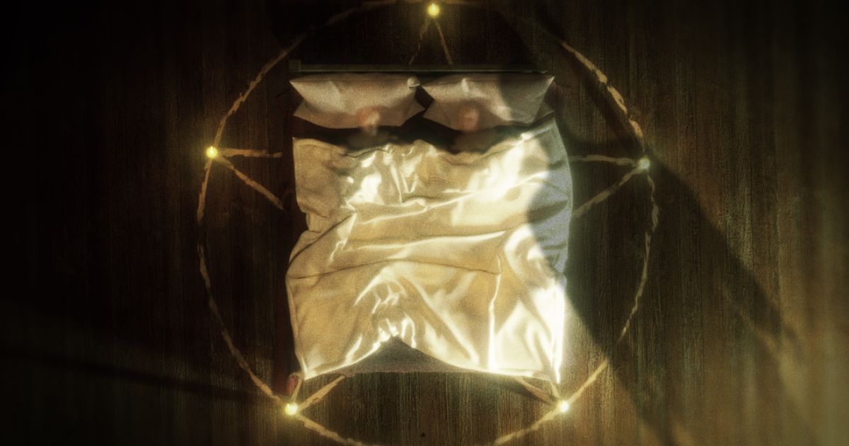 Shot above a bed which has a circle of light round it.