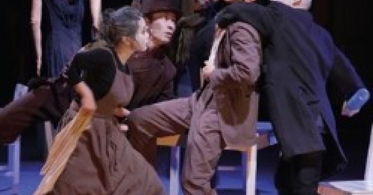 A group of dancers contort around a desk.