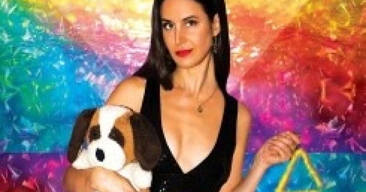 Brooke in a black top and trousers, holding a toy dog, with a rainbow coloured background.