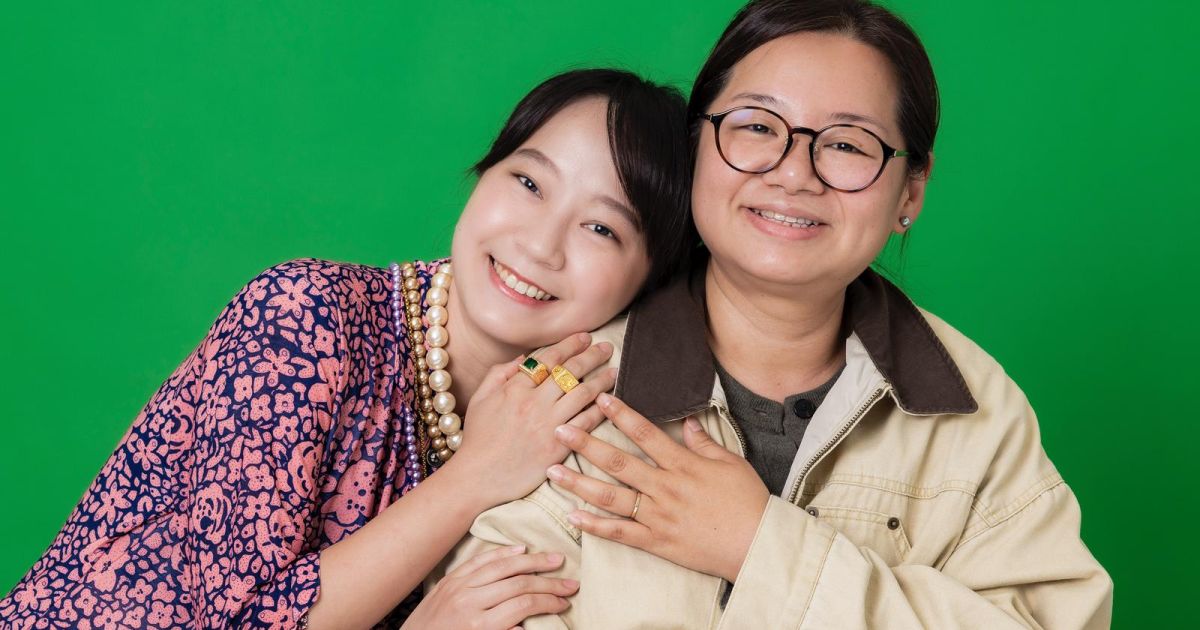 Cathy Lam and Kasen Tsui are pictured hugging, smiling for the camera.
