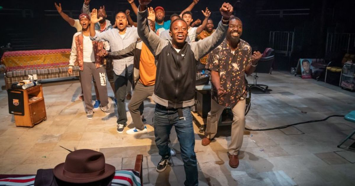 The cast of Barber Shop Chronicles gather round, bringing their energy and projecting it to the audience.
