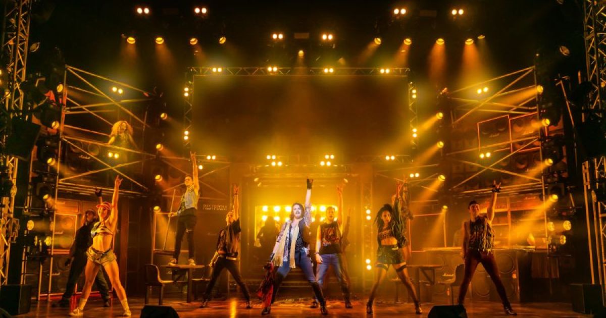 Rock of Ages production shot of ensemble with air punch choreography